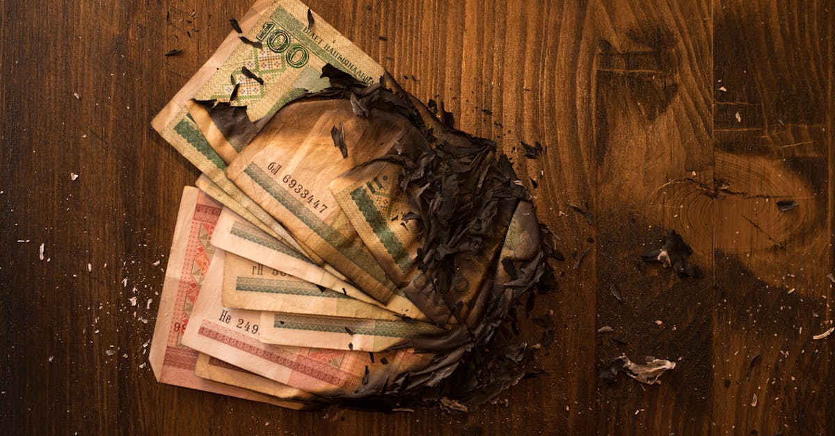 Notas de dinheiro queimadas sobre mesa escura — o custo real da IA subsidiada